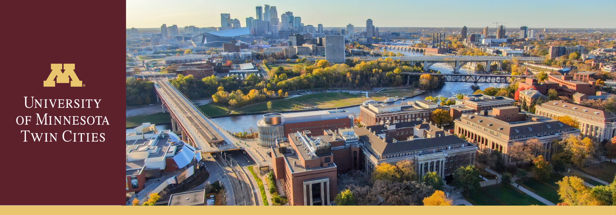 Aerial image of the UMN Minneapolis campus with the Minneapolis city skyline in the background